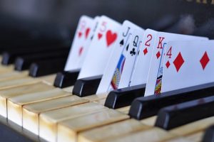 Imagen de un piano con cartas de jugar